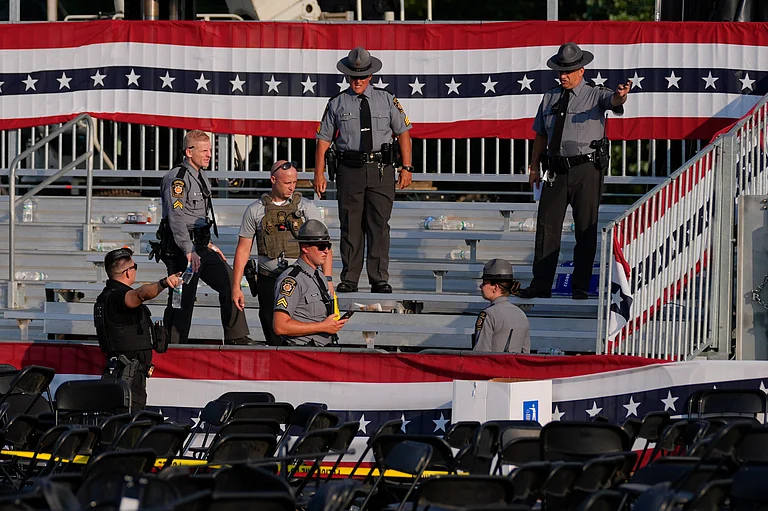 Law enforcement officers gather at the campaign rally site for Republican presidential candidate former President Donald Trump Saturday, July 13, 2024, in Butler, Pa. Trump's campaign said in a statement that the former president was "fine" after a shooting at his rally in Butler  - (AP Photo/Evan Vucci)